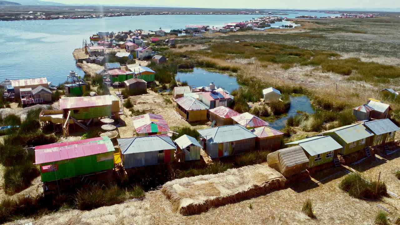 дрон опускается на землю над островом урос, плавающие дома на озере титикака.