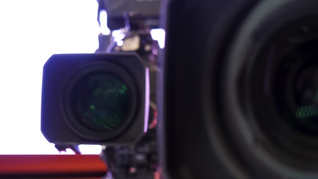 primer plano de una hermosa lente de cámara en un fondo borroso blanco. imágenes de stock. elemento frontal de una lente de cámara con hermosos reflejos de luces de color.