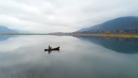 Man-rowing-boat-with-his-dog-on-a-lake-4k