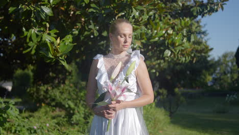 novia en un vestido blanco con un ramo de lirios