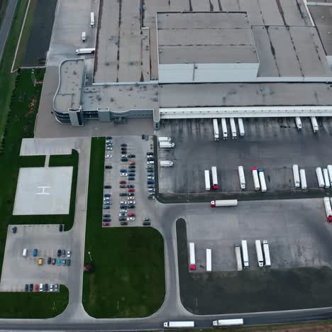 industrial zone on the field. roofs of modern plant with parking places. white trucks and cars on industrial territory on field. aerial view.