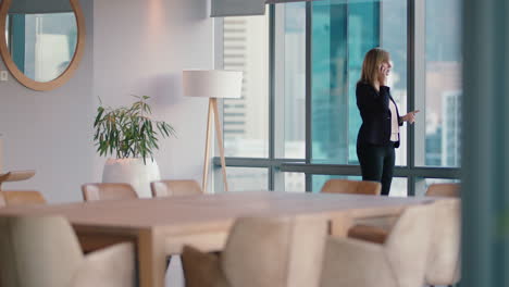 business-woman-using-smartphone-chatting-to-client-negotiating-deal-financial-advisor-sharing-expert-advice-having-phone-call-working-late-in-office-looking-out-window