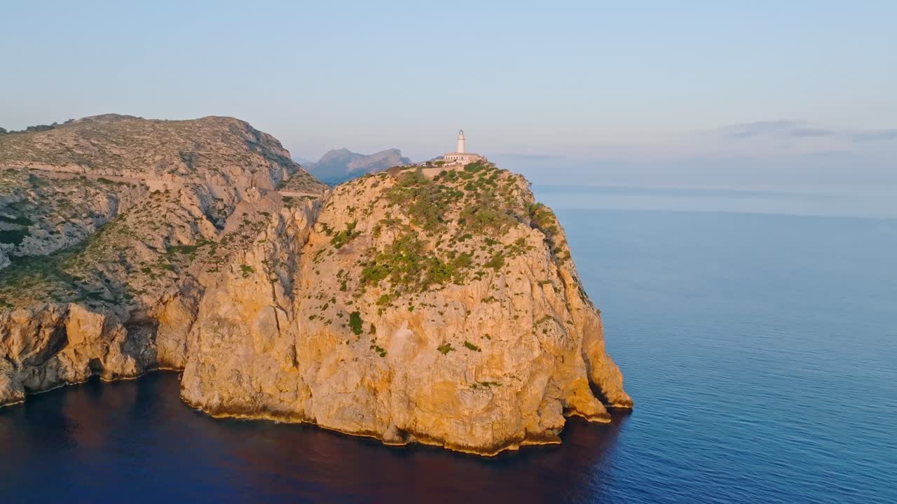 Una scogliera illuminata dal sole che mostra il Faro di Formentor, Serra de Tramuntana, Spagna