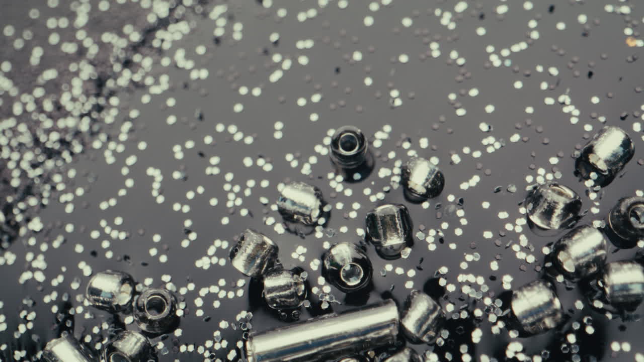 Shiny Silver Beads and Glitter on Dark Background