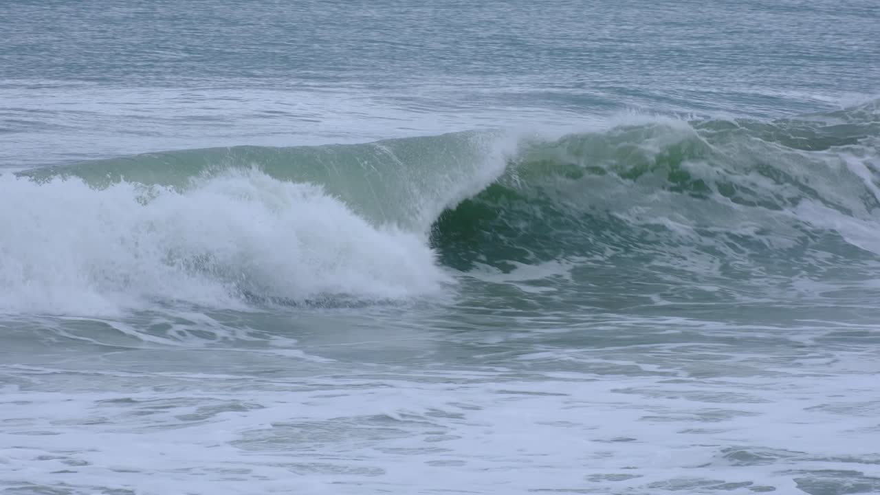 Closeup of frothy whitewash waves rolling and crashing into beach in southern Sri Lanka
