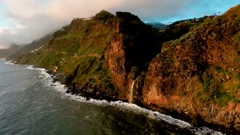 Aerial-sunset-golden-light-at-a-coastal-waterfall,-Madiera,-Portugal