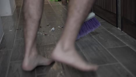 man sweeping the trash with a broom happily