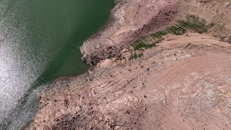 Top-down-aerial-view-of-dry-banks-in-Sau-water-reservoir,-forward,-Spain