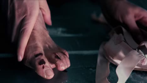 ballerina dancer takes bloody feet out of ballet shoes