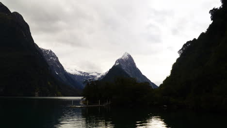 View-of-snowcapped-Mitre-peak-on-the-shore-of-Milford-Sound-on-a-cloudy-day,-Timelpase