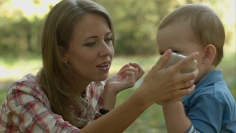 mother helps little son to call his father with telephone