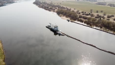 Dredger-deepening-Nemunas-river-in-aerial-side-shot,-Lithuania