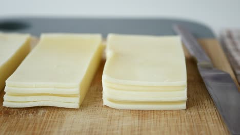 primer plano de queso mozzarella en rodajas en una tabla de cortar