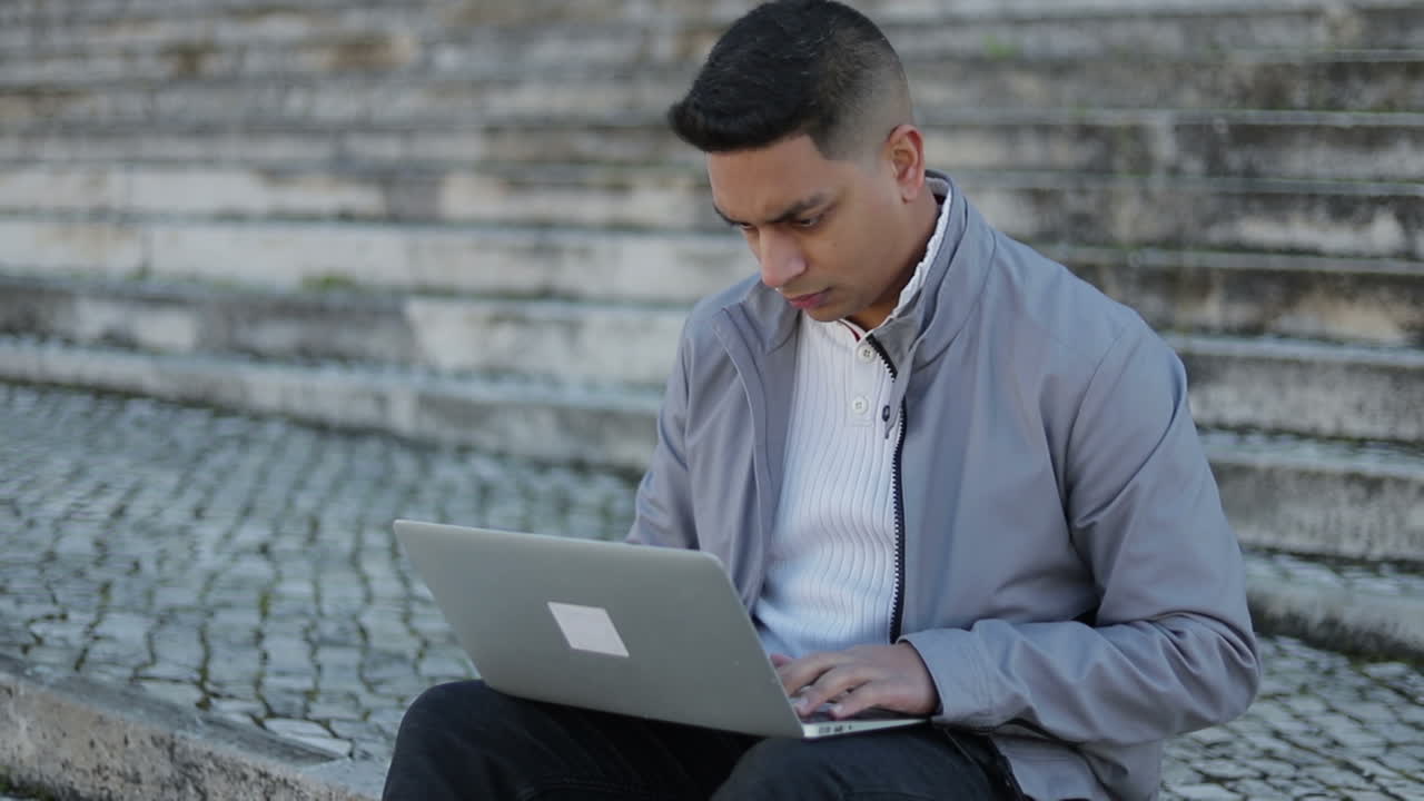 Focused young man typing on laptop