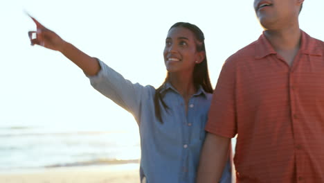 playa, sonrisa y pareja caminando