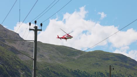 swiss air-rescue helicopter taking off over busy road in switzerland