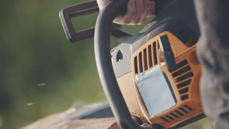 close up of man using chainsaw