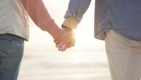 Couple,-sunset-and-holding-hands-at-beach