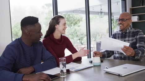 Happy-diverse-couple-and-male-financial-advisor-shaking-hands-at-home