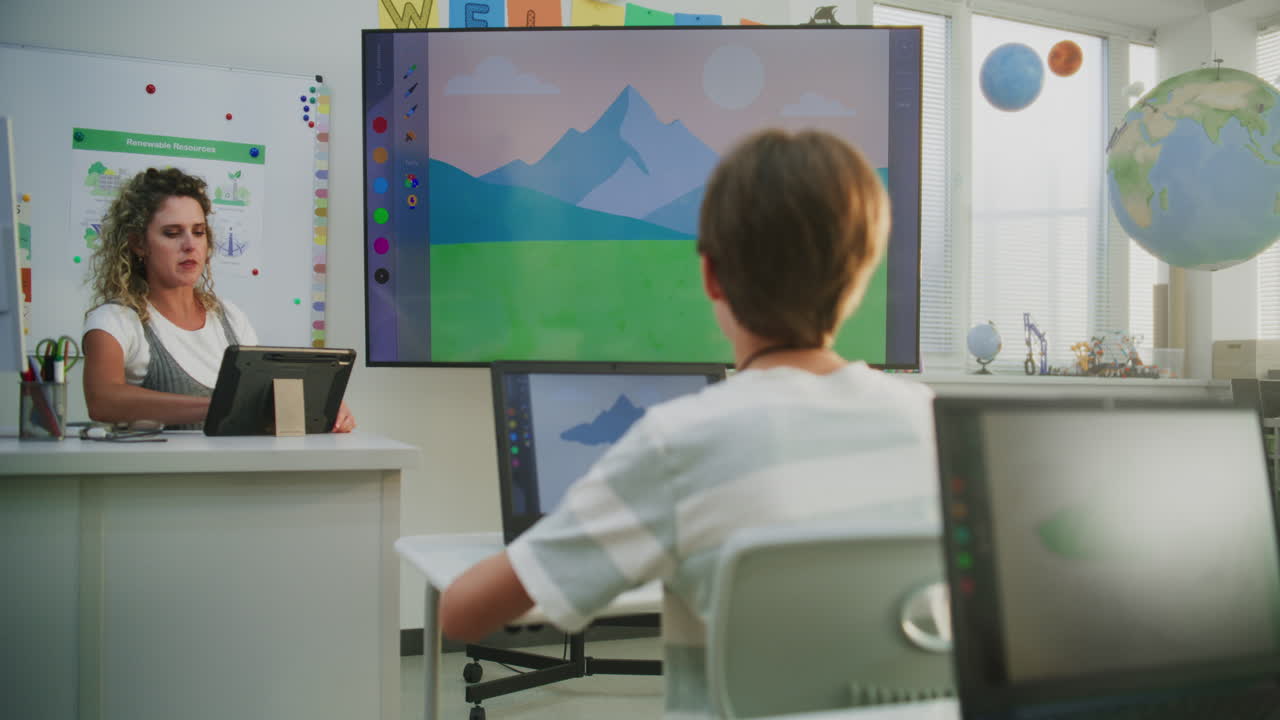 Female Teacher Teaching Young Kids During Art Lesson Using Tablet Computer and Digital Screen