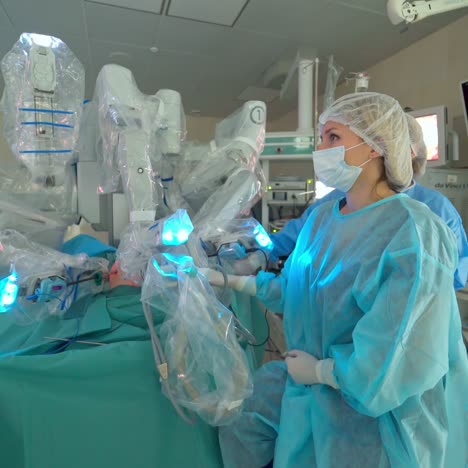 medical operation involving robot. medical robot during operation in clinic. woman surgeon looks on the screen of during robotic surgery
