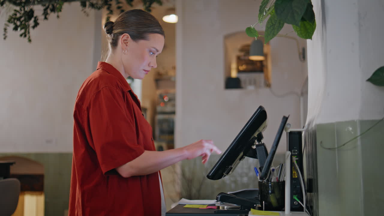Girl working restaurant counter on processing payments closeup. Woman waitress
