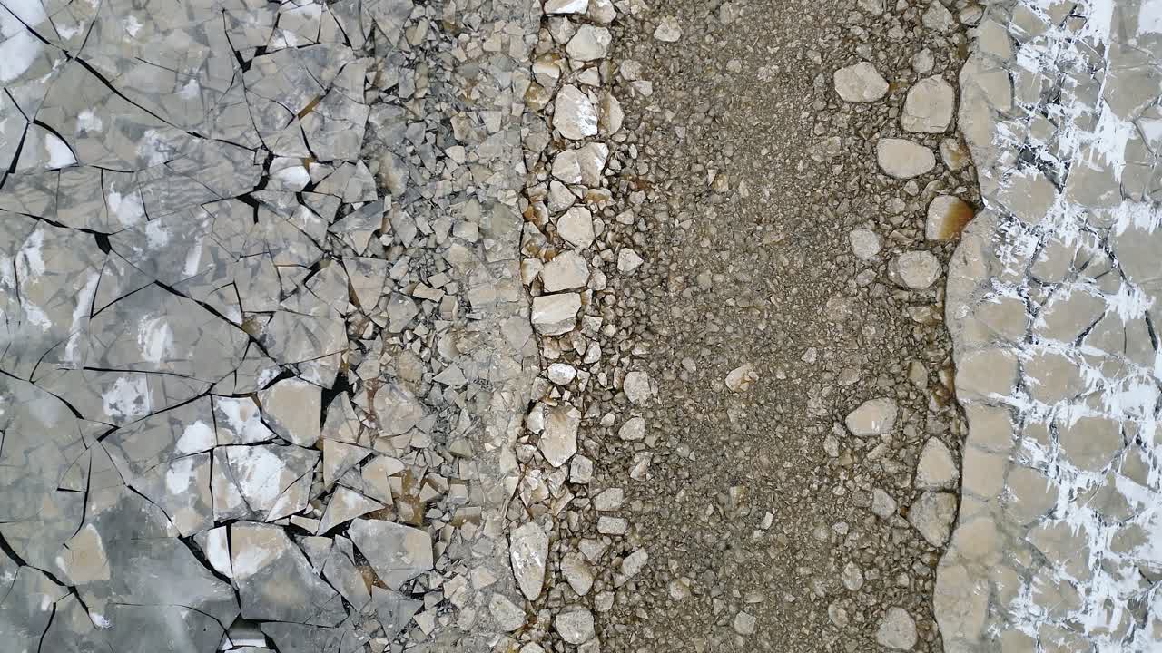 Opbrudt havis og en klippefyldt kystlinje skaber vinterlige naturmønstre