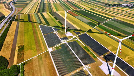 colorful lined agricultural fields with wind farms. powerful wind mills produce green energy. aerial view