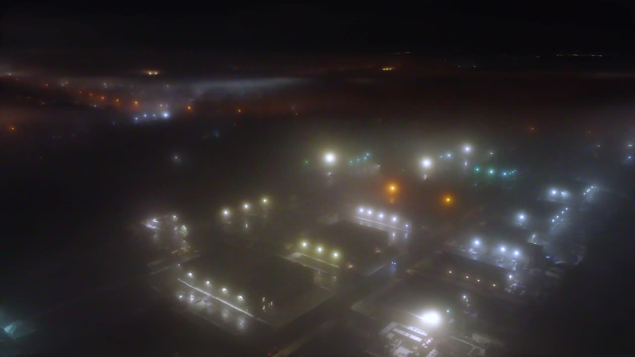Low visibility fog aerial over Canada city at night, drone plane descend window view