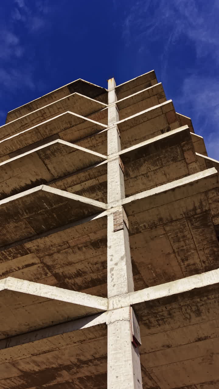 Ein Beton-Frame erhebt sich vor einem klaren, blauen Himmel und zeigt architektonischen Fortschritt und Baufortschritt