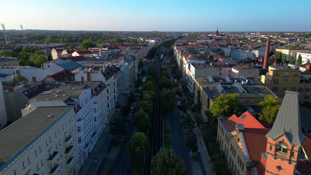 Yellow elevated train running through a residential area of berlin at summer. Great aerial view flight overflight flyover drone