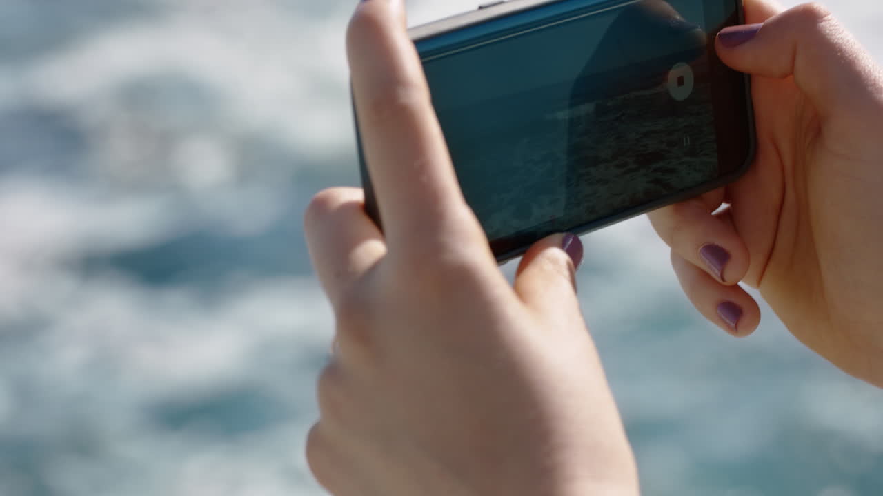 manos cercanas mujer tomando una foto usando un teléfono inteligente de la hermosa playa compartiendo vacaciones de verano en las redes sociales