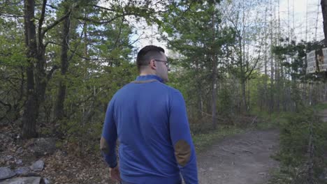 man following a hiking trail in the woodlands in the woodlands of bulgaria