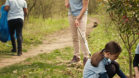 Diverse-volunteers-team-planting-trees-seeds-in-the-forest