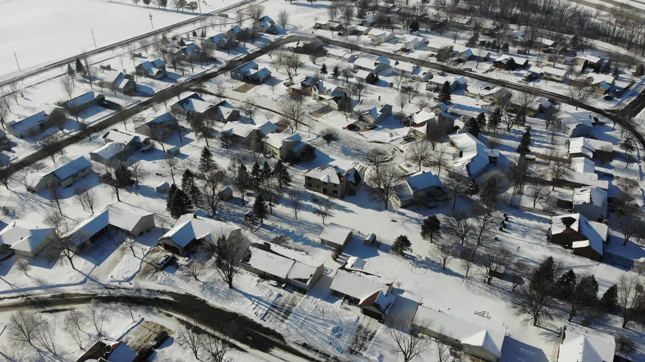 겨울에 눈이 내리는 작은 교외 중서부 마을의 4k 드론 항공 영상