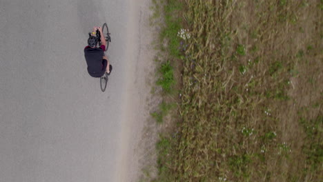 Overhead-View-Of-A-Cyclist-Riding-A-Bike-On-The-RoadPassing-By-On-Fields