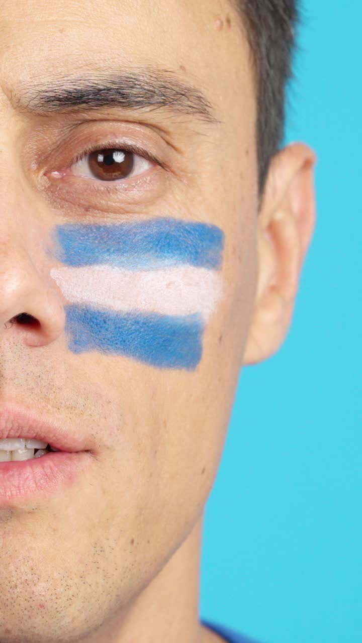 Man with a salvadoran flag painted on the face smiling