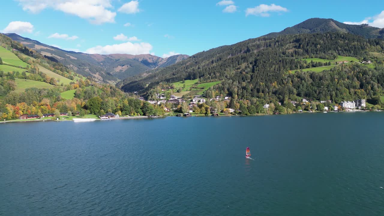 windsurfista en el lago zeller see durante el verano en zell am see, austria - 4k circular aéreo