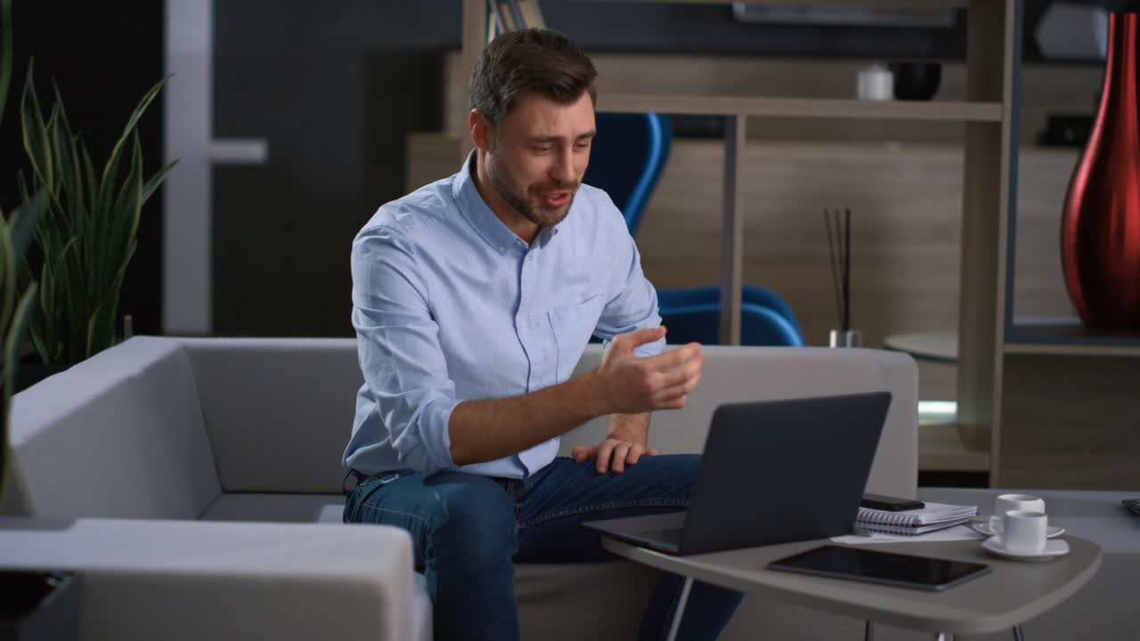 empresario emocionado liderando una videoconferencia usando una computadora portátil en la oficina de una compañía de tecnología