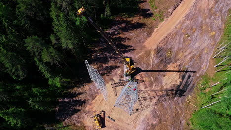 Luftaufnahme-Von-Oben-Nach-Unten-Von-Arbeitern,-Die-Metallübertragungsmasten-Installieren-Und-Kranen