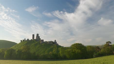 panning shot of corfe castle and surrounding purbeck hills in the early morning light