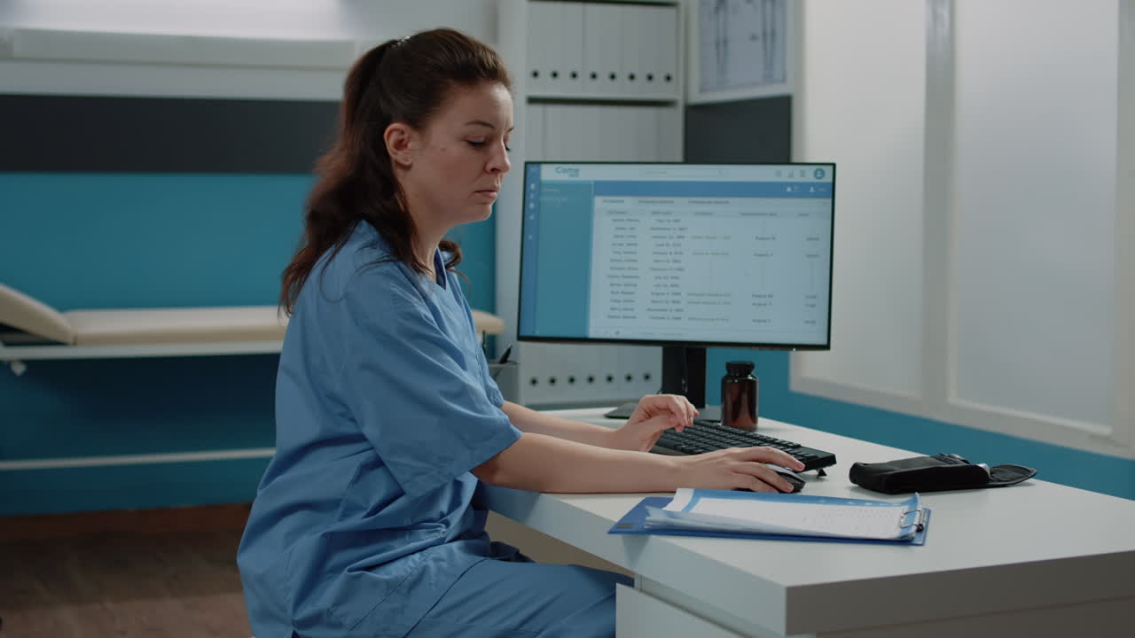 Medical Professional Working at Computer in Clinic