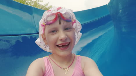 funny girl in white panamke rides from the water slide and makes a ridiculous selfie on the camera