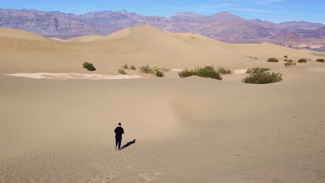 man walk and leaving footprints on sand dunes at death valley california