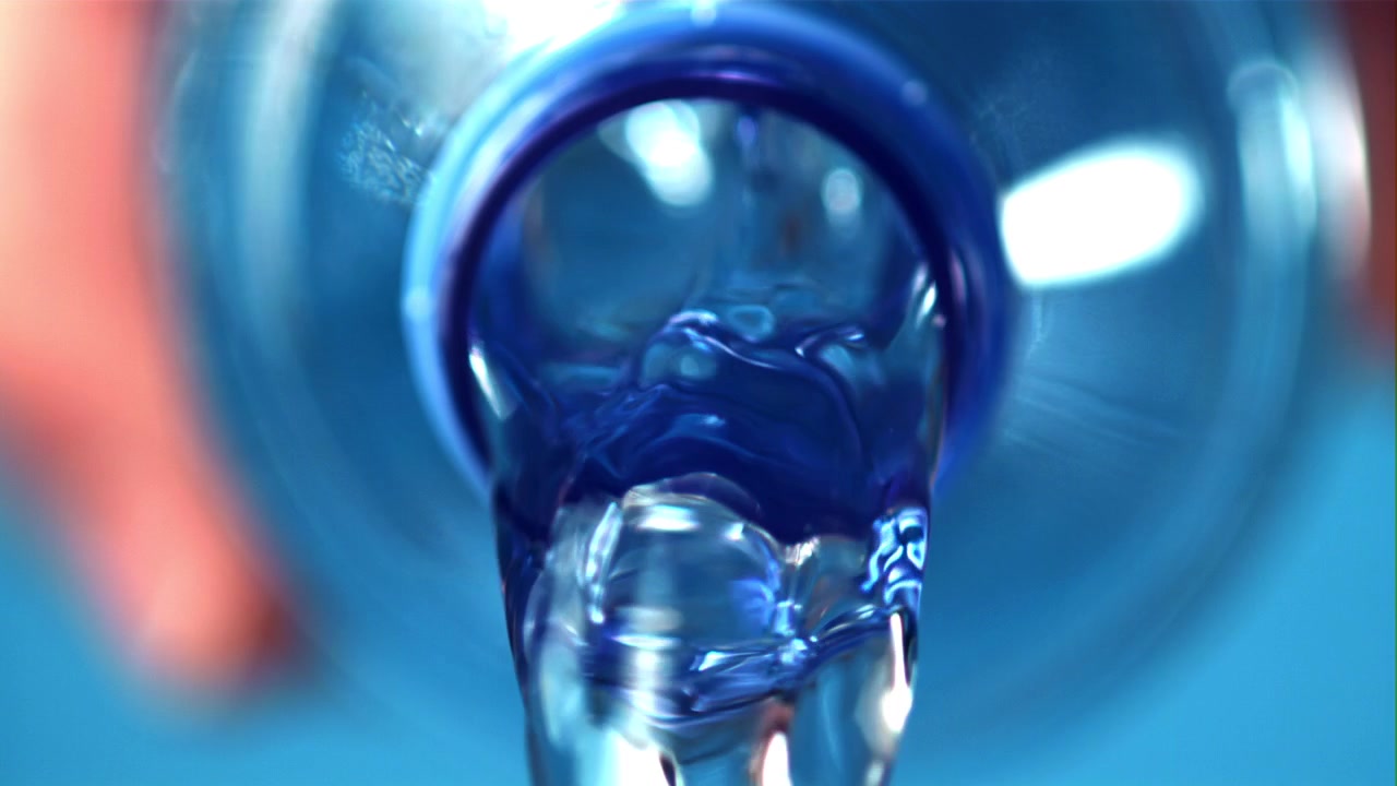 Clear Water Flowing from a Blue Plastic Bottle in Slow Motion