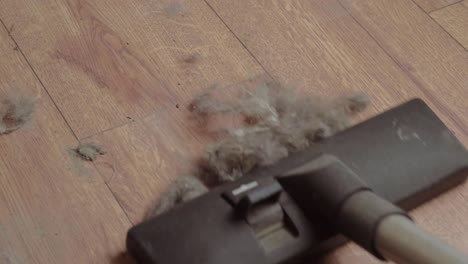 hoovering a dirty dusty floor with an electric vacuum