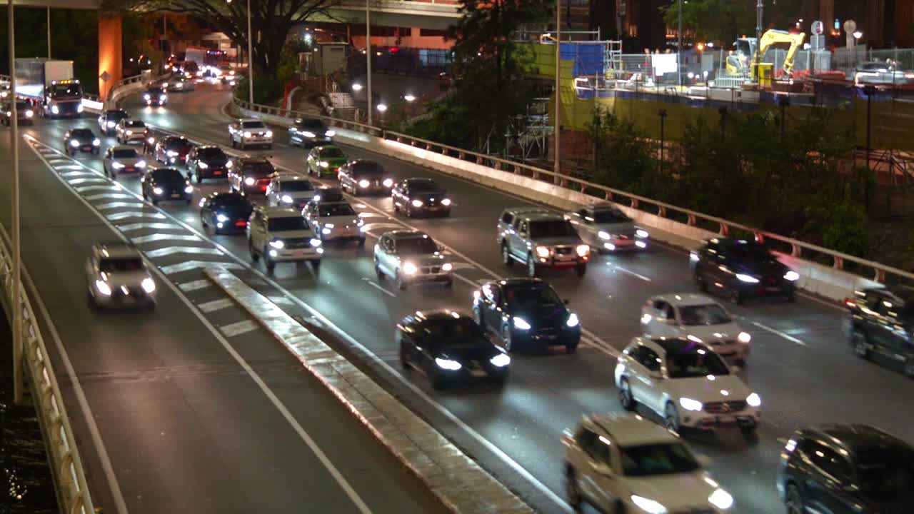 Time-lapse shot capturing busy inbound vehicles traffic on major corridor M3 Pacific motorway at night, Brisbane CBD.