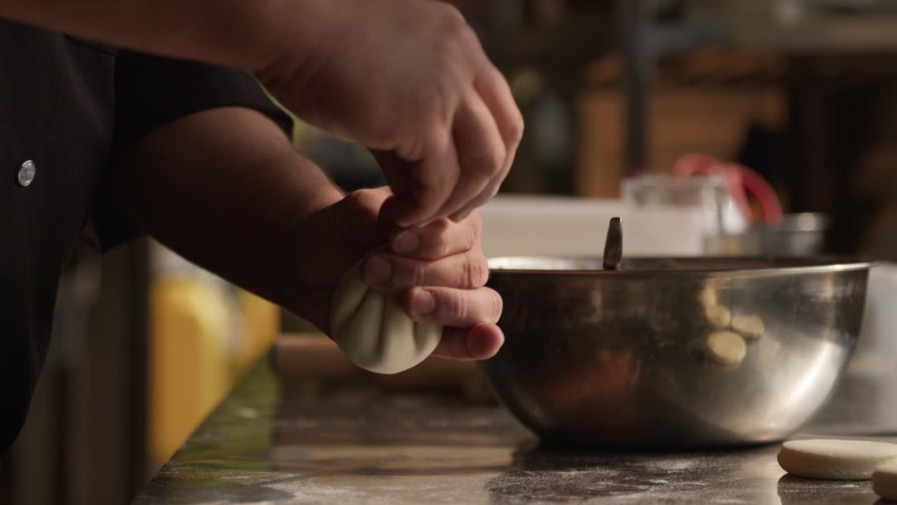 chef haciendo albóndigas de manti en la cocina de un restaurante, tiro de mano
