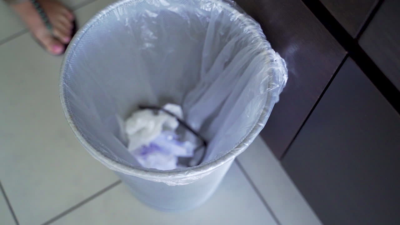 Woman throwing eyeglasses into trash bin