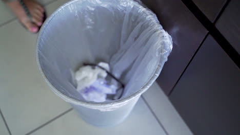 mujer tirando anteojos a la basura